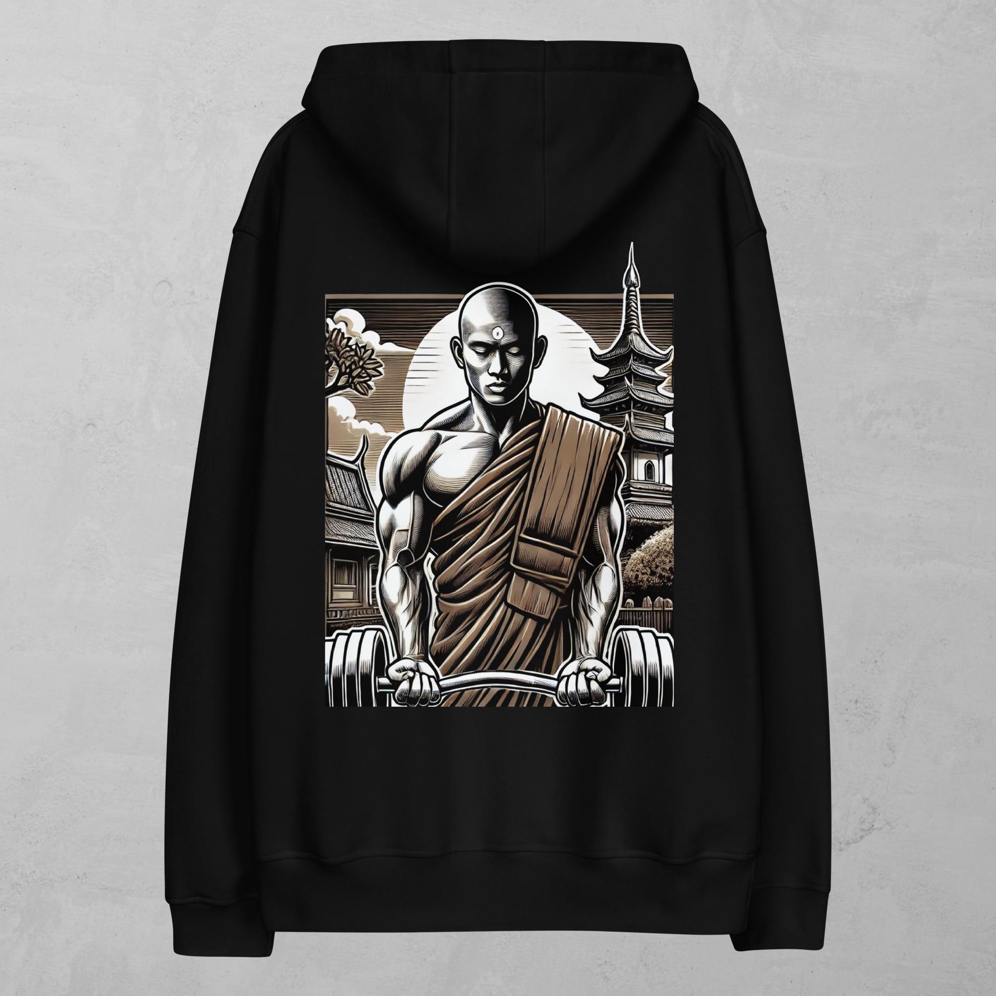 A black hoodie featuring a striking design of a muscular monk holding weights in front of a traditional pagoda. The monk wears a robe over one shoulder, showcasing his strength and calm demeanor. The background includes a full moon and detailed clouds, enhancing the balance between power and serenity. This hoodie combines elements of fitness and mindfulness, symbolizing the Alphamonks brand values of strength and inner peace.